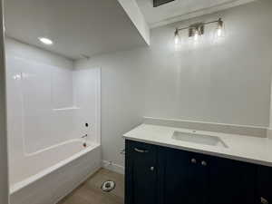 Full bath featuring vanity, a textured ceiling, bathtub / shower combination, and light wood-type flooring