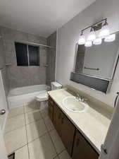 Bathroom featuring vanity, shower / bathtub combination, light tile patterned floors, a textured ceiling, and a textured wall
