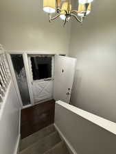 Stairway featuring a chandelier and wood finished floors