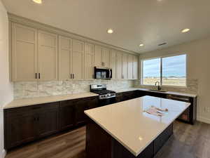 Kitchen featuring stainless steel appliances, a center island, dark wood finished floors, backsplash, and recessed lighting