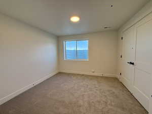 Unfurnished bedroom featuring carpet flooring and a closet