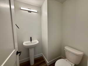 Bathroom featuring toilet and dark wood finished floors
