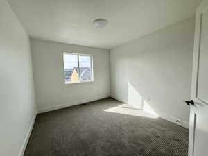 Carpeted empty room featuring baseboards