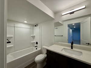 Full bathroom featuring vanity, washtub / shower combination, a textured ceiling, and dark wood-type flooring