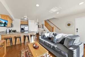Living area with dark wood-type flooring and recessed lighting