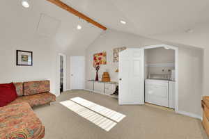Living room featuring light carpet, washing machine and dryer, and recessed lighting