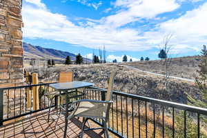 Balcony featuring outdoor dining area and a mountain view