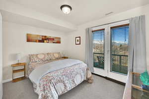 Carpeted bedroom with baseboards and access to outside