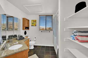 Full bath featuring vanity, shower / bath combo with shower curtain, and stone finish floors