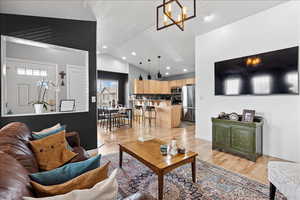 Living area featuring lofted ceiling, light wood-style flooring, and hanging lights