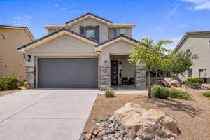 Mediterranean / spanish-style house with stone siding, driveway, stucco siding, and an attached garage