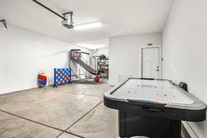Recreation room with a garage, concrete floors, and a textured ceiling