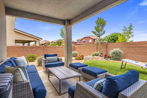 Fenced backyard featuring an outdoor hangout area and a patio