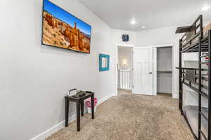 Hall with light carpet and recessed lighting