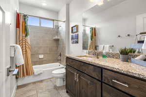 Bathroom with vanity, shower / bath combo, and light tile patterned floors