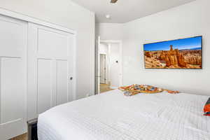 Carpeted bedroom with a closet and ceiling fan