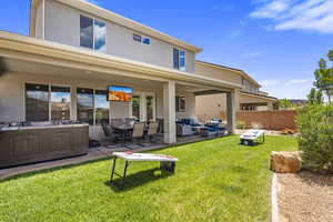 Rear view of property featuring stucco siding, a patio, and an outdoor living / dining area