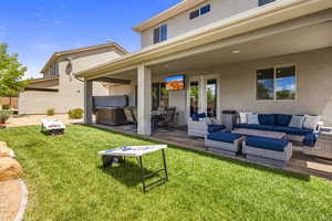 Back of house featuring a hot tub, a patio, french doors, and stucco siding