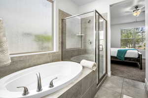 Full bathroom featuring a bath, a stall shower, ensuite bath, tile patterned floors, and a ceiling fan