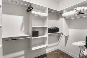 Walk in closet with dark carpet