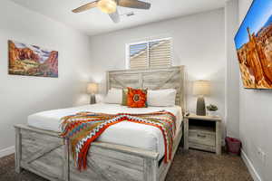 Bedroom with dark carpet and ceiling fan