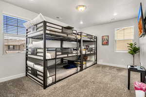Bedroom with light colored carpet and recessed lighting