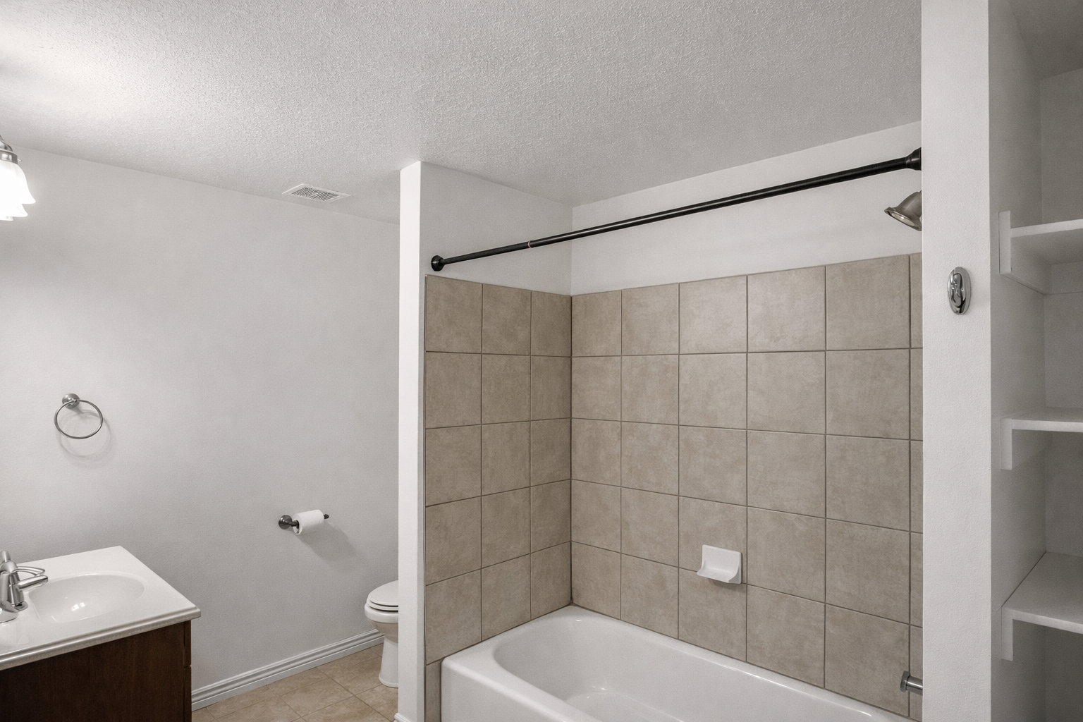 Full bathroom featuring vanity, shower / bath combination, a textured ceiling, and light tile patterned floors