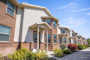 Doorway to property with stucco siding and brick siding