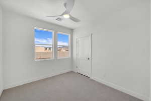 Carpeted spare room featuring baseboards and ceiling fan