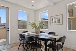 Dining space featuring light wood-style floors, recessed lighting, and beamed ceiling