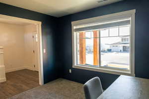 Home office featuring dark colored carpet and baseboards