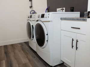 Laundry room with dark wood-style flooring and washing machine and clothes dryer