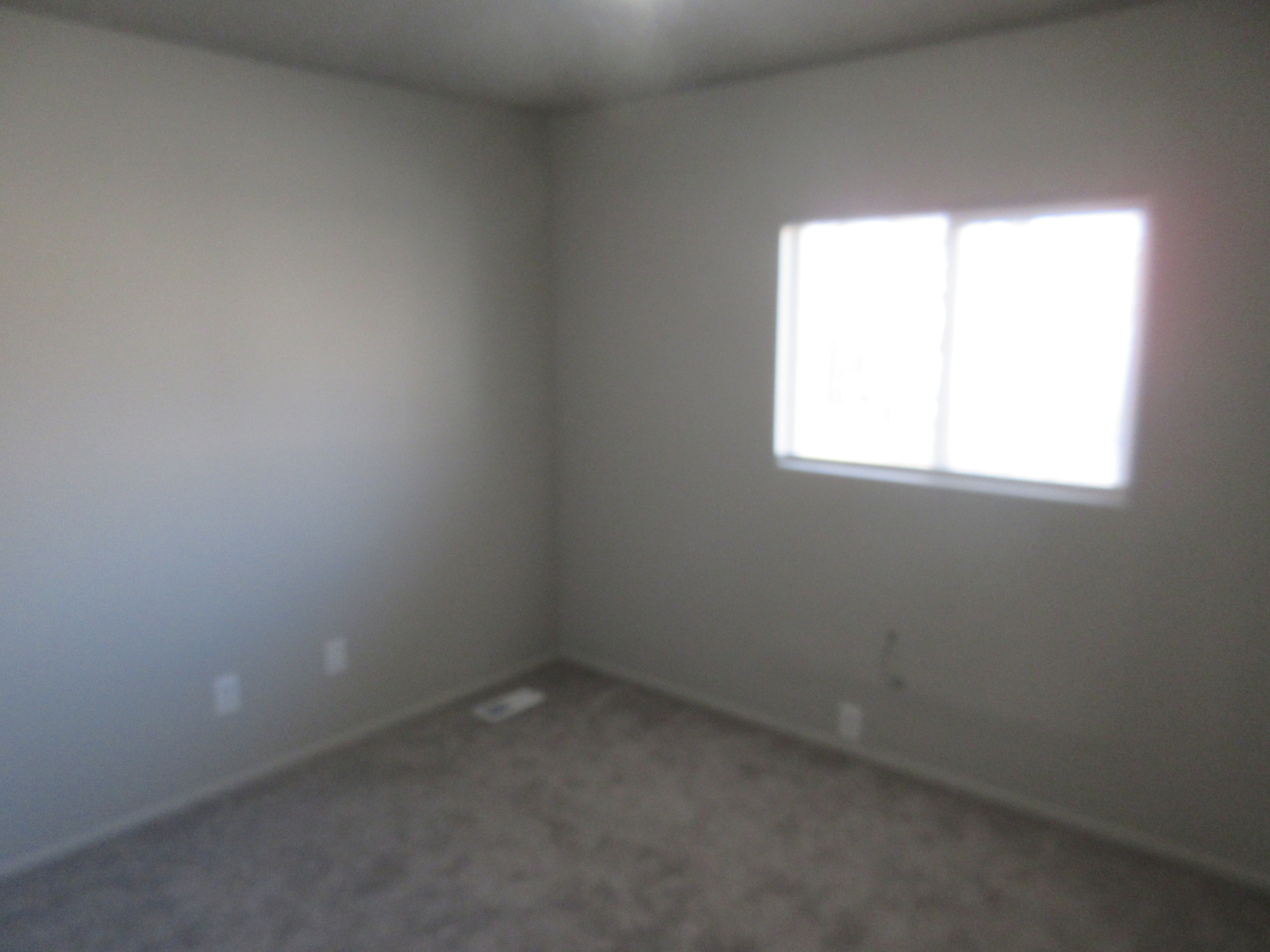 Empty room featuring dark colored carpet