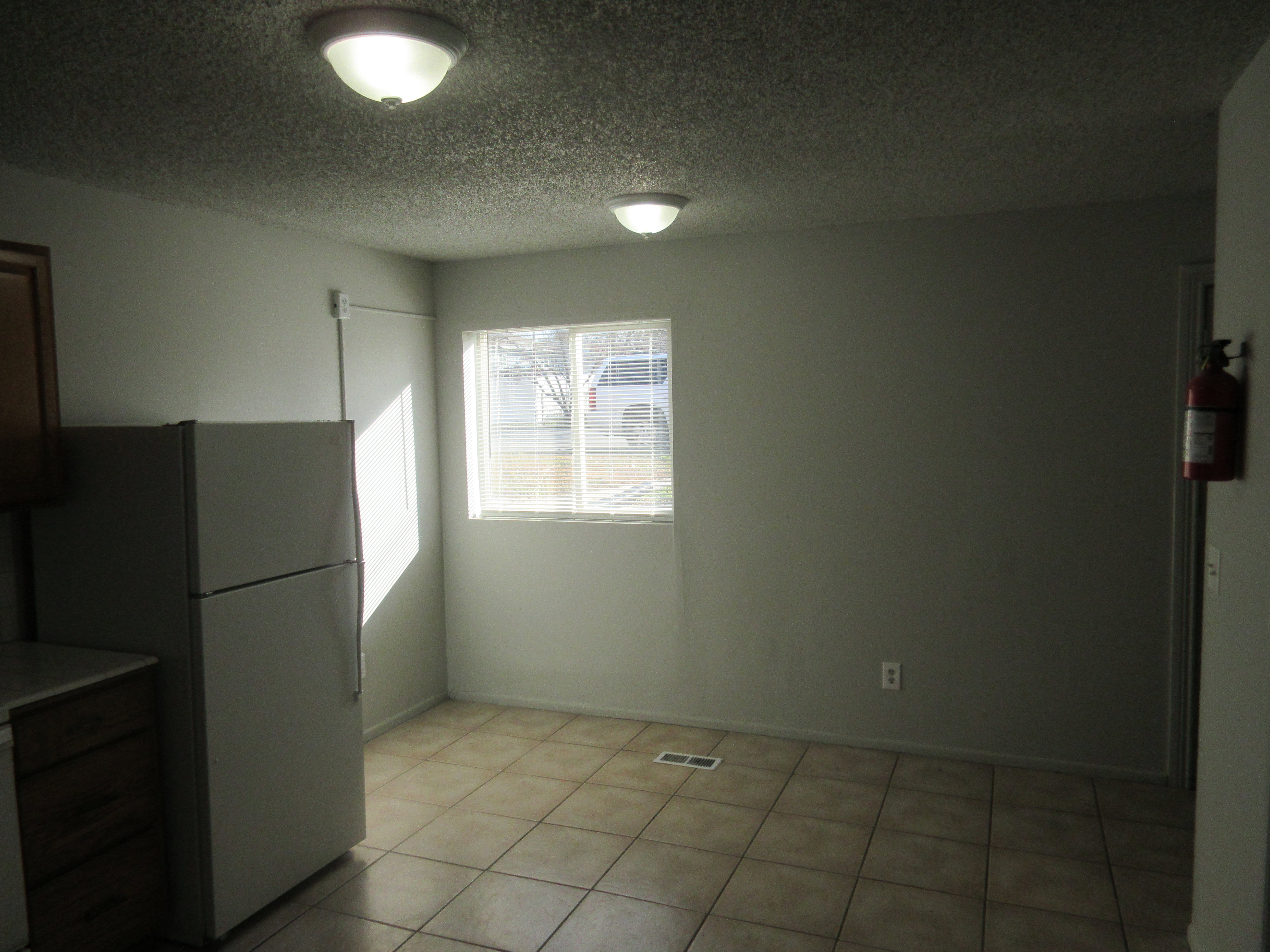 Unfurnished dining area featuring a textured ceiling and light tile patterned floors