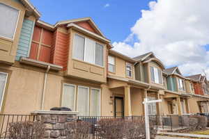 View of front facade with stucco siding, a porch, and a residential view