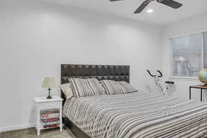 Carpeted bedroom with baseboards and ceiling fan