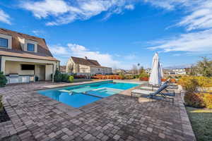 Relaxing pool / spa with area for grilling and a patio area