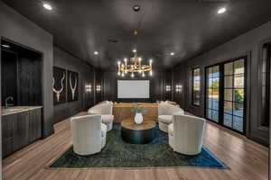 Home theater featuring french doors, wood finished floors, and recessed lighting