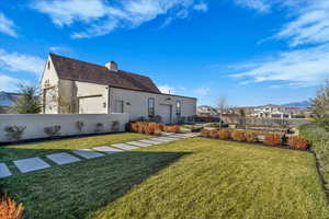 Rear view of property with stucco siding, a chimney, and a residential view