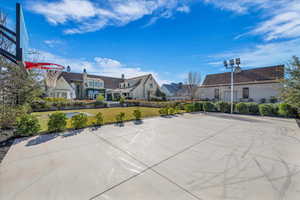 View of sport court with a lawn