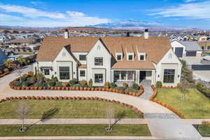 View of front of house with a chimney, roof with shingles, a front lawn, a residential view, and a mountain view
