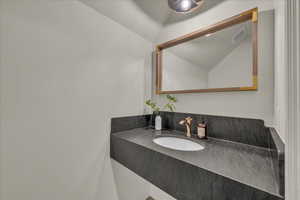 Bathroom featuring vanity and lofted ceiling