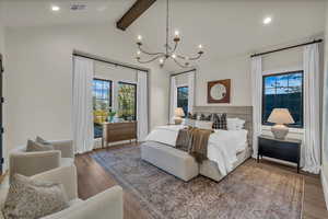 Bedroom with a chandelier, hardwood / wood-style flooring, lofted ceiling, and multiple windows