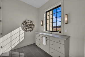 Bathroom with vanity and dark tile patterned flooring