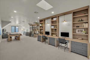 Office area with light colored carpet, recessed lighting, and a skylight