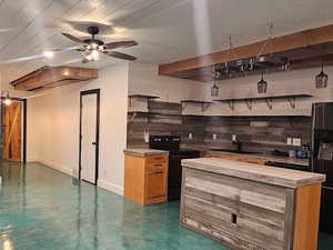 Kitchen with black appliances, concrete flooring, light countertops, ceiling fan, and wood finish cabinets