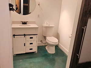 Half bath featuring concrete flooring and vanity