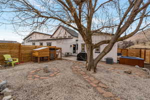 Rear view of house featuring a fenced backyard, a patio, and a hot tub