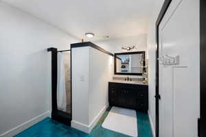 Full bath featuring a stall shower and vanity