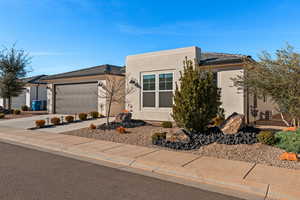 View of front facade featuring driveway, a garage, stucco siding, and a tiled roof